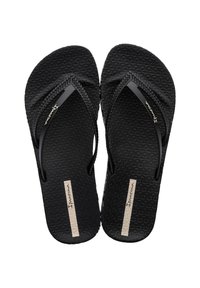 Chanclas negras con plantilla texturizada, tiras trenzadas y un acento de logo rectangular. Diseño simple adecuado para un uso casual.