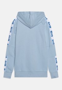 Sudadera azul clara con bolsillo frontal tipo canguro, capucha con cordón y franjas laterales que presentan el texto "ALL★STAR" en azul sobre fondo blanco.