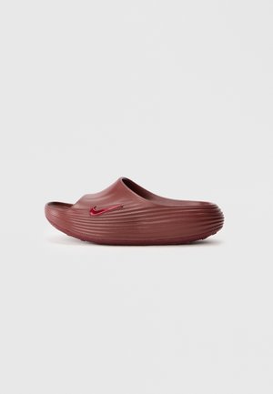 Mocassin en maroon à enfiler avec un côté texturé et le logo swoosh rouge de Nike sur un fond uni.