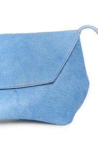 Pochette bleu clair en fourrure douce et texturée, avec fermeture à rabat et forme arrondie. Coutures apparentes sur les bords. Aucun élément métallique visible.