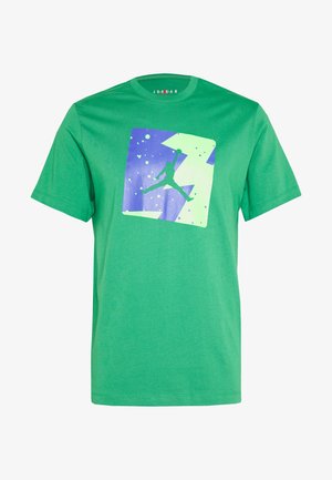 Camiseta de algodón verde con un cuadrado gráfico azul y verde que presenta una silueta en el aire, mangas cortas y cuello redondo.