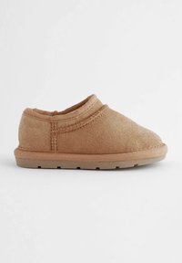 Bruine slipper met een zachte suède-achtige buitenkant, ronde neus, elastische opening en een platte rubberen zool. Naaddetails accentueren het ontwerp.