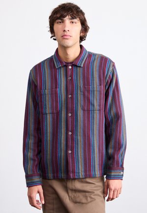 Multi-colored shirt featuring vertical stripes in maroon, blue, and green. Includes two chest pockets and button-up front with a collar.