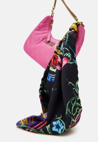 Rosa vadderad handväska med en gyllene kedjesnodd, i kombination med en svart sidenhalsduk med ett blommigt mönster i livliga färger.