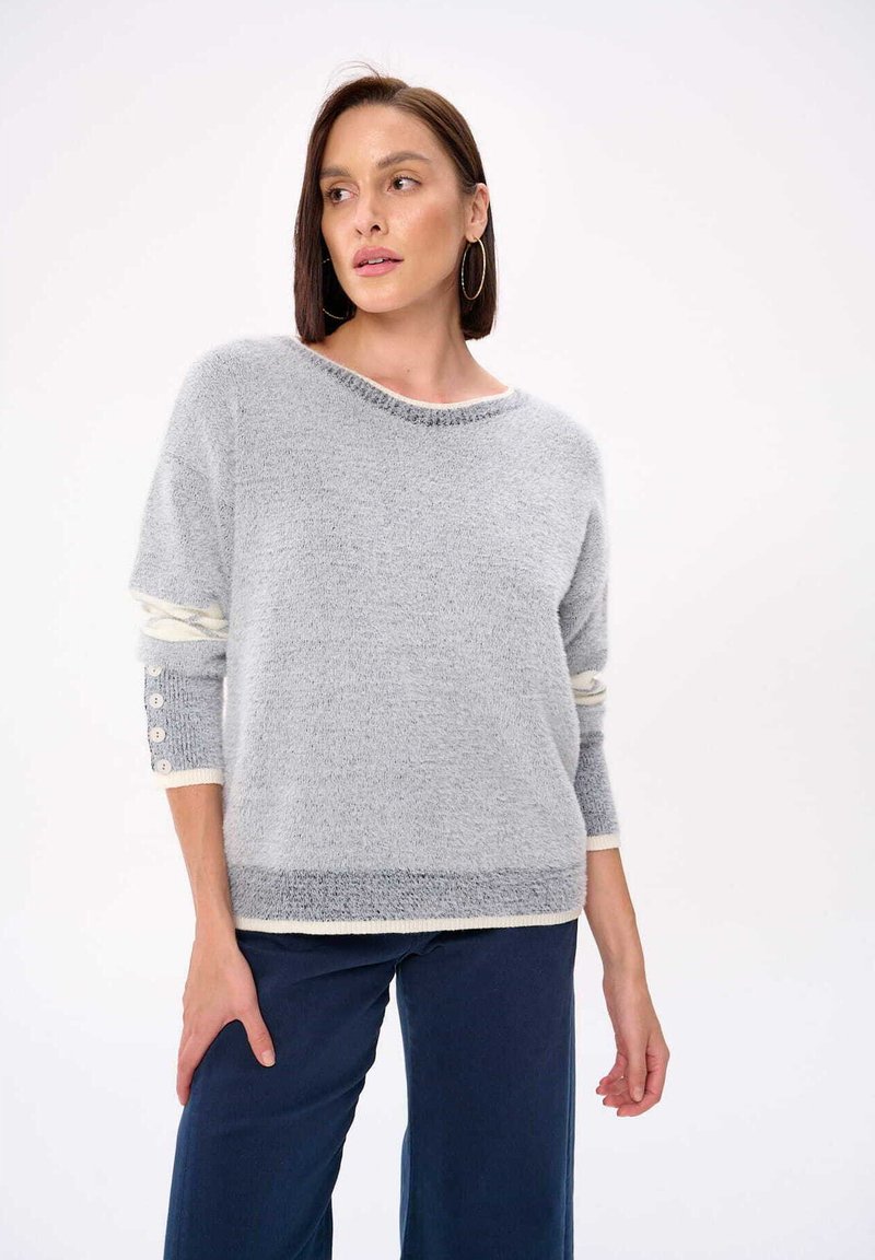 Hellgrauer Strickpullover mit weitem Ausschnitt, langen Ärmeln mit cremefarbenen Akzenten und dekorativen Knöpfen an den Bündchen.