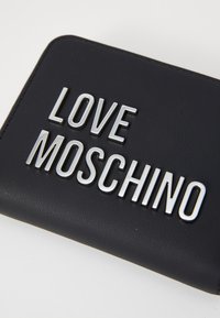 Carteira preta feita de imitação de couro com letras em relevo prateadas que dizem "LOVE MOSCHINO." Textura suave com bordas costuradas.