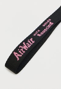 Μαύρο πλεγμένο λουράκι με ροζ κεντημένο κείμενο που λέει "AirHatz with Soles Bouncing", με επίπεδη, υφή επιφάνεια.