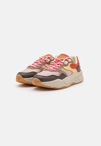 Sneakers w połączeniu beżowych, brązowych i pomarańczowych paneli, z różowymi sznurowadłami i teksturowaną gumową podeszwą zapewniającą przyczepność.