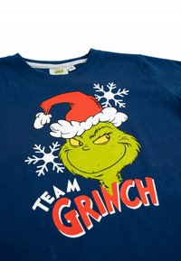 T-shirt in cotone blu navy con una grafica del Grinch che indossa un cappello di Babbo Natale rosso e fiocchi di neve, con la scritta "TEAM GRINCH" in grassetto rosso e bianco.