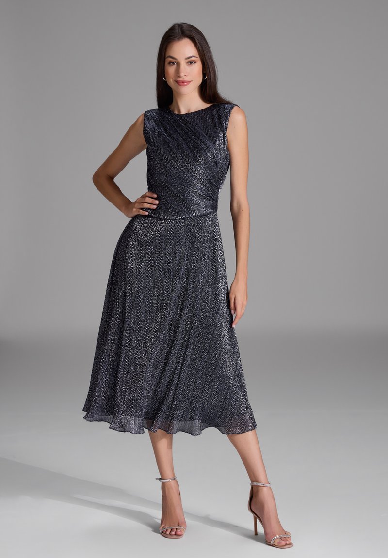 Robe sans manches, longueur genoux en bleu foncé avec un motif texturé. Corsage ajusté se transforme en une jupe évasée avec un léger brillant.