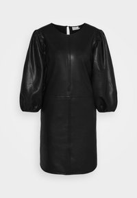 Robe noire en cuir synthétique avec manches longues bouffantes, encolure ronde et détails de coutures devant et à la taille, fermeture dos avec une ouverture en forme de goutte.