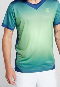 Sportovní tričko s krátkým rukávem v gradientní zelené do modré, s véčkovým výstřihem, síťovanou strukturou a logem na hrudi.