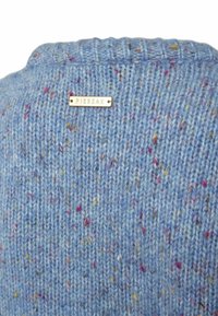 Sinine kudumisega sviiter tekstureeritud pinnaga, millel on värvilised laigud ja väike metallmärk, millel on tekst "PIESZAK" seljal.