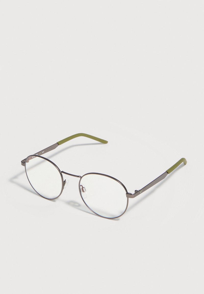 Rundbrille mit Metallgestell, dünnen silbernen Rändern und olivgrünen Bügelenden, liegend auf einer weißen Oberfläche.