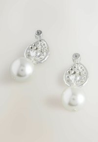 Hõbedast kõrvarõngad, millel on tekstuuriga kroonlehe kujuline aktsent suure, helendava valge pärli kohal. Ainulaadne detailimine hõbeda sees.