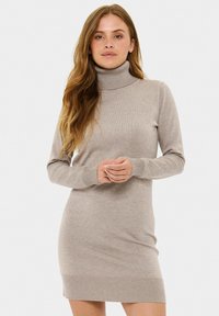 Šviesiai rudas megztas turtlenecko suknel�ė ilgomis rankovėmis, su briaunuotais rankogalviais ir apatine dalimi. Minkšta tekstūra ir prilipęs dizainas, siekiantis iki vidurio šlaunies.