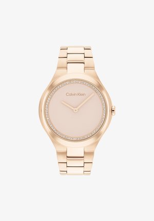 Reloj de Calvin Klein en oro rosado con un dial redondo, de color rosa claro, y acentos de cristal a lo largo del bisel. Estilo de pulsera de eslabones metálicos.