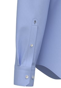 Jasnoniebieski mankiet długiego rękawa koszuli z dwoma białymi guzikami oraz małym haftowanym detalem w postaci róży blisko zakładki rękawa.