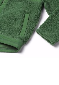 Giacca in pile verde con superficie morbida e strutturata, dotata di chiusura con zip, tasca laterale e orlo e polsini a coste.