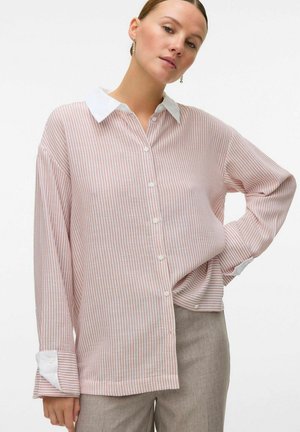 Camisa de botones con rayas verticales rojas y blancas, manga larga, cuello blanco y puños enrollados. Fabricada en tejido ligero.