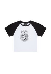 Camiseta blanca de mangas cortas con mangas raglán negras. Presenta un estampado gráfico de un corazón rodeado por diseños similares a espinas. Material de algodón.