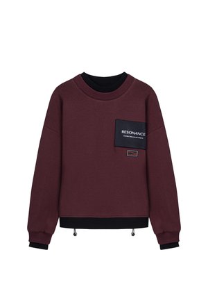 Bordeaux sweatshirt gemaakt van zachte stof met een zwarte ribbelboord aan de hals en manchetten. Heeft een borstzak met de tekst "RESONANCE" en een verstelbare zoom.