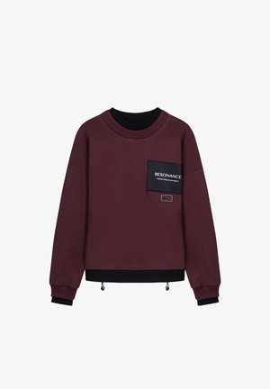 Bordeaux sweatshirt gemaakt van zachte stof met een zwarte ribbelboord aan de hals en manchetten. Heeft een borstzak met de tekst "RESONANCE" en een verstelbare zoom.