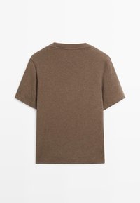 Jednoduché hnědé krátké tričko s kulatým výstřihem zobrazené zezadu na bílém pozadí.