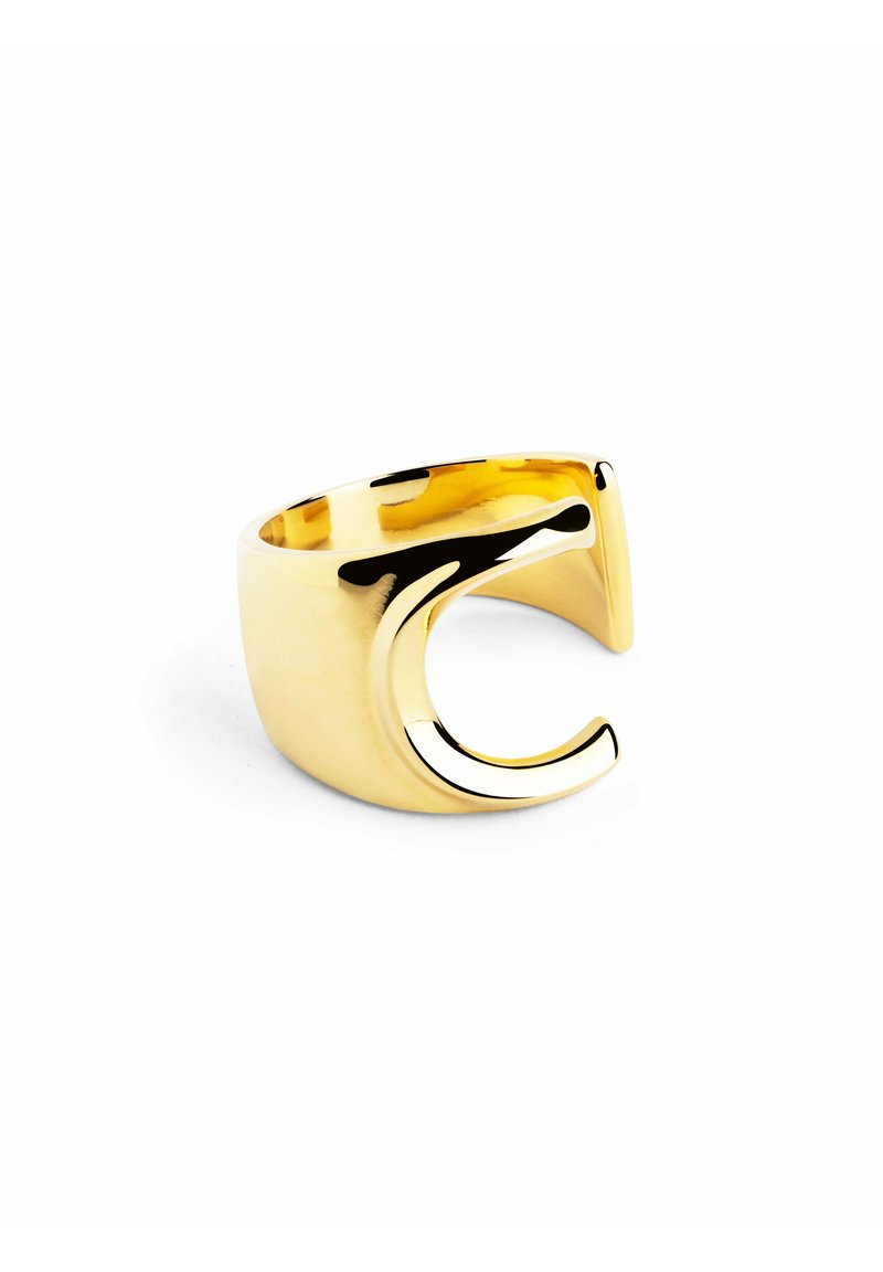 Anello in metallo color oro con una fascia larga e un design a curva aperta stilizzata su un lato. Superficie liscia e lucida con una finitura lucidata.