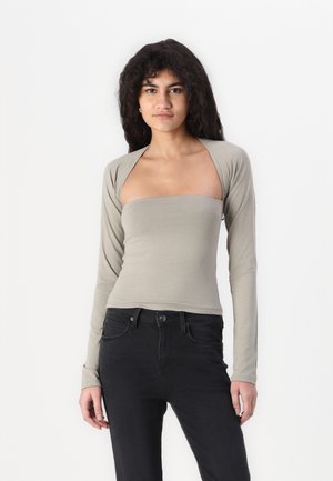 Light gray long-sleeve top with a scoop neckline and fitted design, made from a soft fabric; paired with black jeans.
