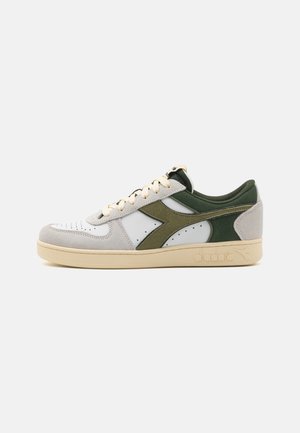 Sneaker con design in pelle bianca e suede verde, punta rotonda, suola intermedia color marrone chiaro e lacci crema a contrasto con dettagli perforati.