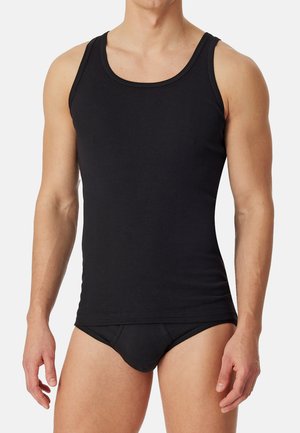 Schwarzes Tanktop aus einem Stoff mit glatter Textur, mit Rundhalsausschnitt und breiten Trägern. Kombiniert mit schwarzen Unterhosen.