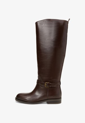 Botte en cuir brun foncé, haute, avec une boucle sur le côté, un petit talon, un bout arrondi et une languette à l'arrière.