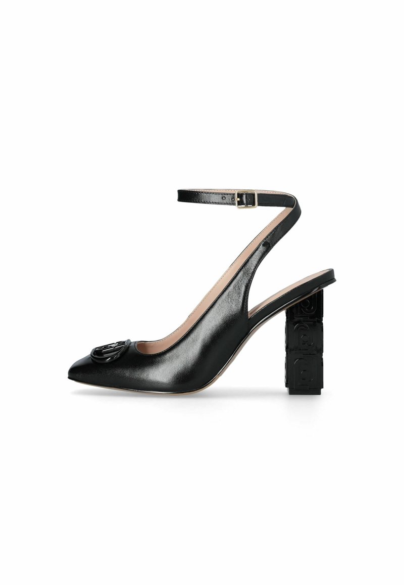 Chaussure noire en cuir à bout pointu avec un accent de logo décoratif sur l'avant et un talon bloc texturé. Bride ajustable à la cheville.