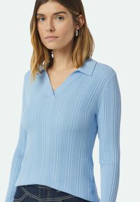 Hellblaues, geripptes Strickpullover mit V-Ausschnitt und Kragen, langen Ärmeln und einem leicht asymmetrischen Saum.