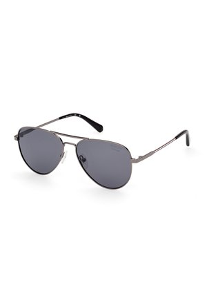 Occhiali da sole aviator con lenti grigie scure, montatura in metallo argentato e punte delle aste in plastica nera. Design leggero con morbidi naselli trasparenti.
