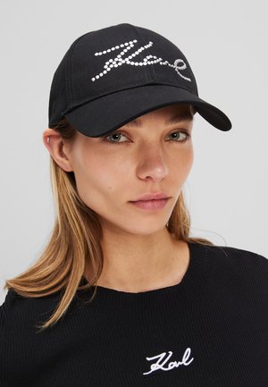 Schwarze Baseballmütze aus Stoff mit einem mit Strass verzierten "Karl"-Logo auf der Vorderseite, einem gebogenen Schild und einem verstellbaren Riemen.