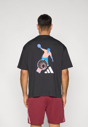 Black short-sleeve t-shirt featuring a colorful graphic of a basketball player with a hoop and the Adidas logo on the back.