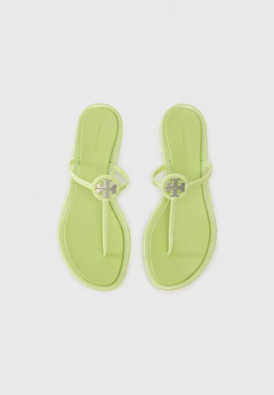 Sandale flip-flop din cauciuc verde, cu un finisaj lucios. Prezintă un accent rotund cu logo argintiu pe brâu și un design cu talpă plată.