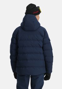 Dunkelblaues Daunenjacke mit Kapuze, die horizontale Steppabschnitte, ein verstaubares Design und ein dezentes Logodetail auf dem Rücken aufweist.
