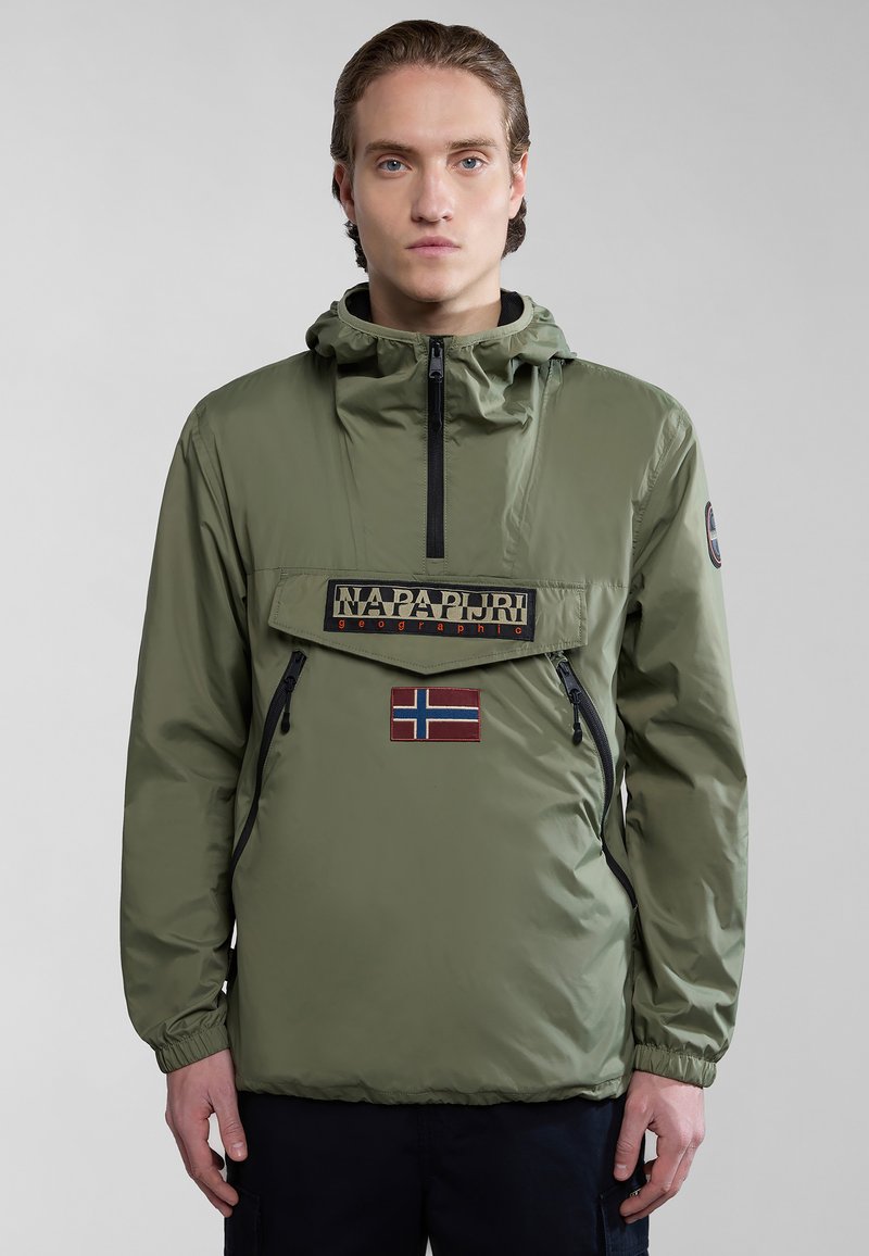 Chaqueta pullover de nailon verde con un bolsillo frontal, cremallera, parche con logo y detalle de bandera noruega. Puños elásticos y capucha para un ajuste ajustable.