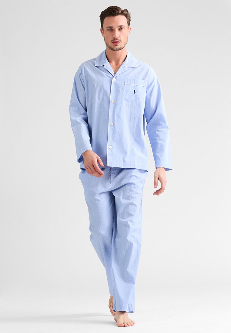 Conjunto de pijama em algodão listrado azul claro, com mangas longas, camisa com botões, bolso no peito e calças a condizer. Textura suave, ajuste casual.