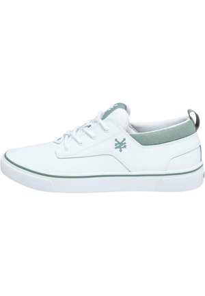 White canvas sneakers with a green accent on the heel, round toe, lace-up design, and textured rubber sole. Features a logo detail on the side.