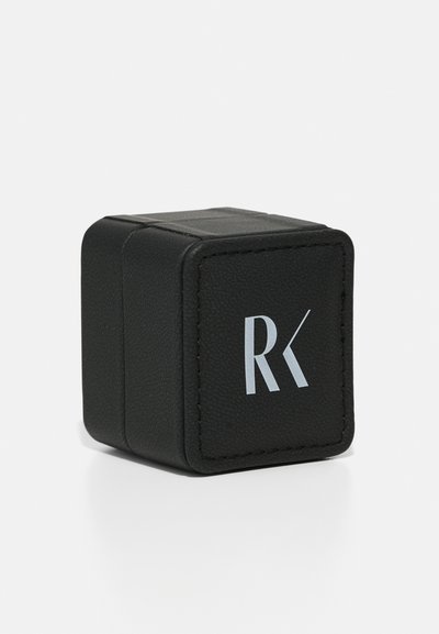 Black rectangular box made of textured leather with a silver logo on the front, features stitched edges and a magnetic closure.