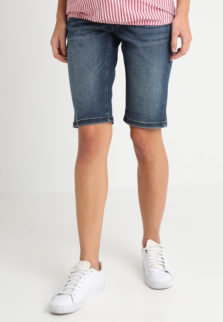 Denim bermudashorts i mörkblått, med medelhög midja och uppvikta fållar. Tillsammans med vita sneakers för en avslappnad och bekväm look.
