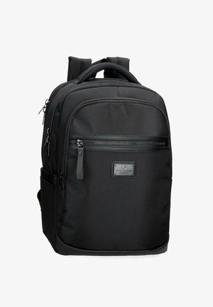 Zaino nero in nylon con spallacci imbottiti, tasca frontale con cerniera, maniglia superiore, tasche laterali e una piccola etichetta rettangolare del marchio sul davanti.