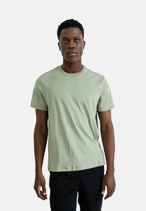 Camiseta de algodón verde claro con cuello redondo y mangas cortas. Presenta un logo sutil en el pecho y un corte relajado.