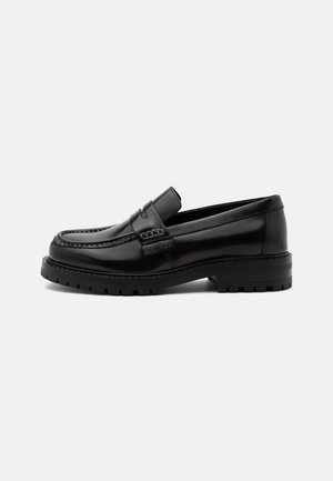 Czarny wypolerowany skórzany loafers z grubą gumową podeszwą i przeszyciami na nosku typu moc toe, z boku z wytłoczonym nazwą marki.