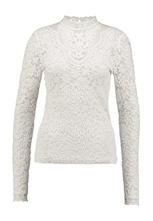 White long-sleeve top made of lace with floral patterns. Features a high neckline and sheer texture throughout.