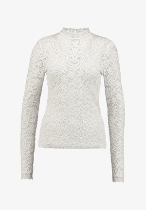 Top de mangas longas branco feito de renda com padrões florais. Apresenta um decote alto e uma textura translúcida por toda a peça.